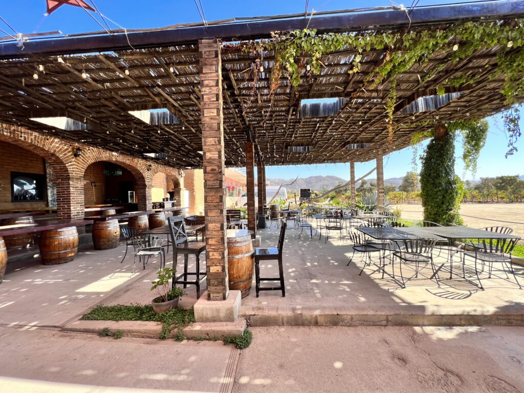 A patio with tables and chairs under an awning.