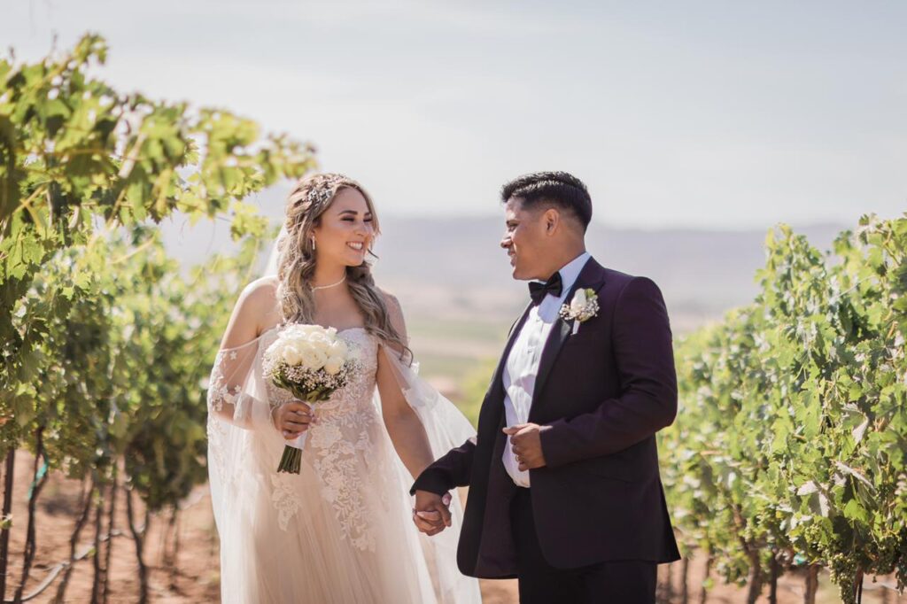 A man and woman holding hands in front of some trees