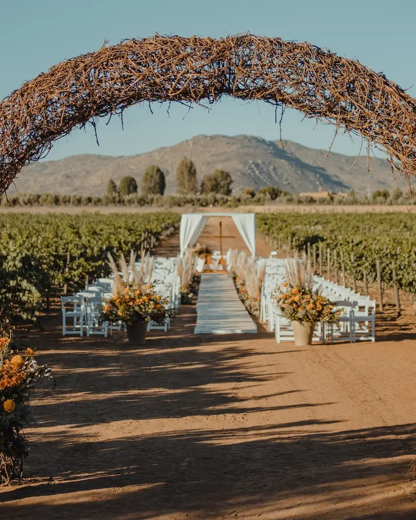A wedding ceremony with chairs and an arch.