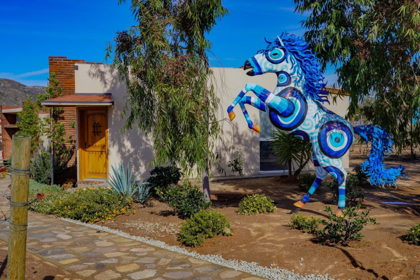 A blue horse statue in front of a building.