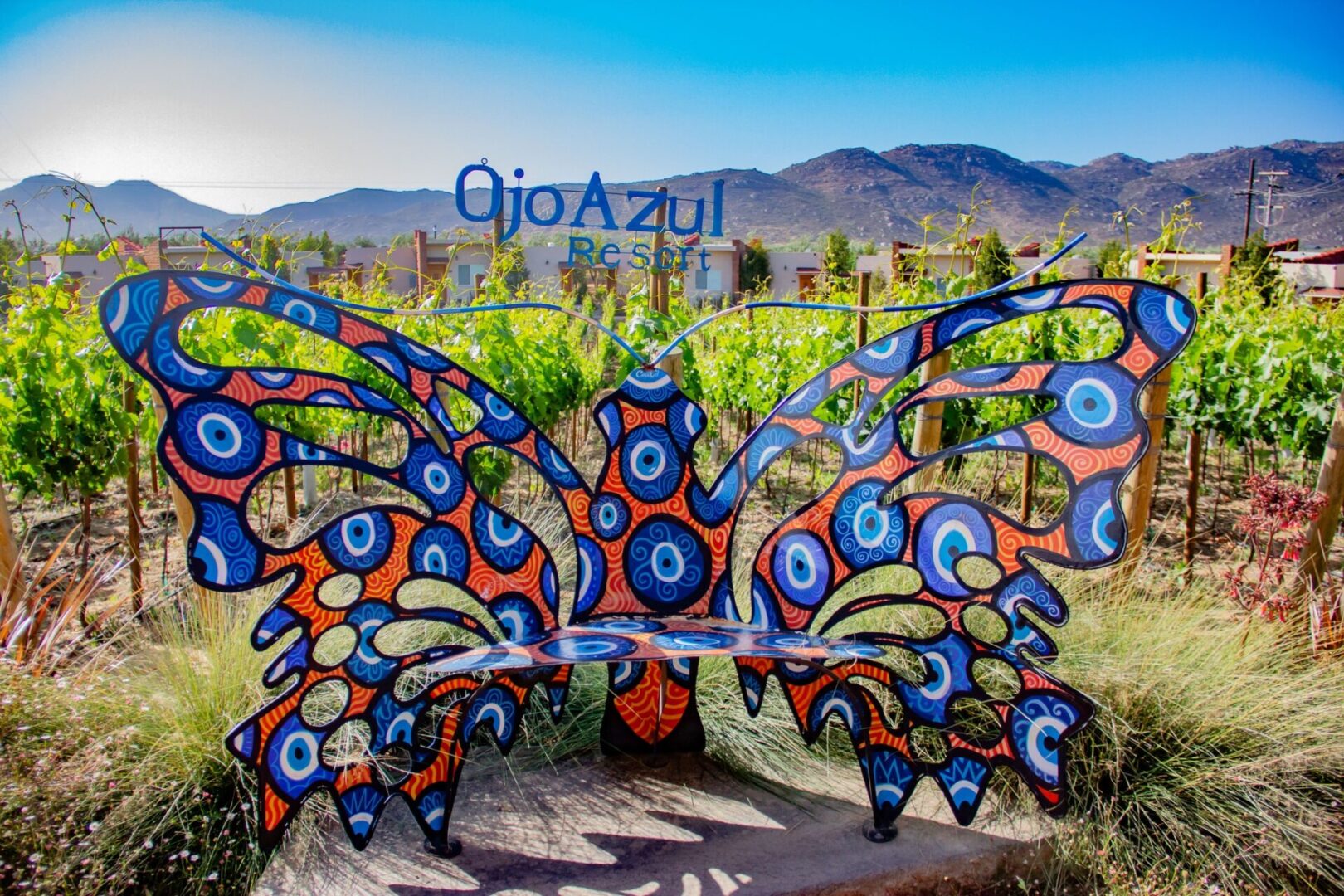 A colorful butterfly sculpture in the middle of a field.